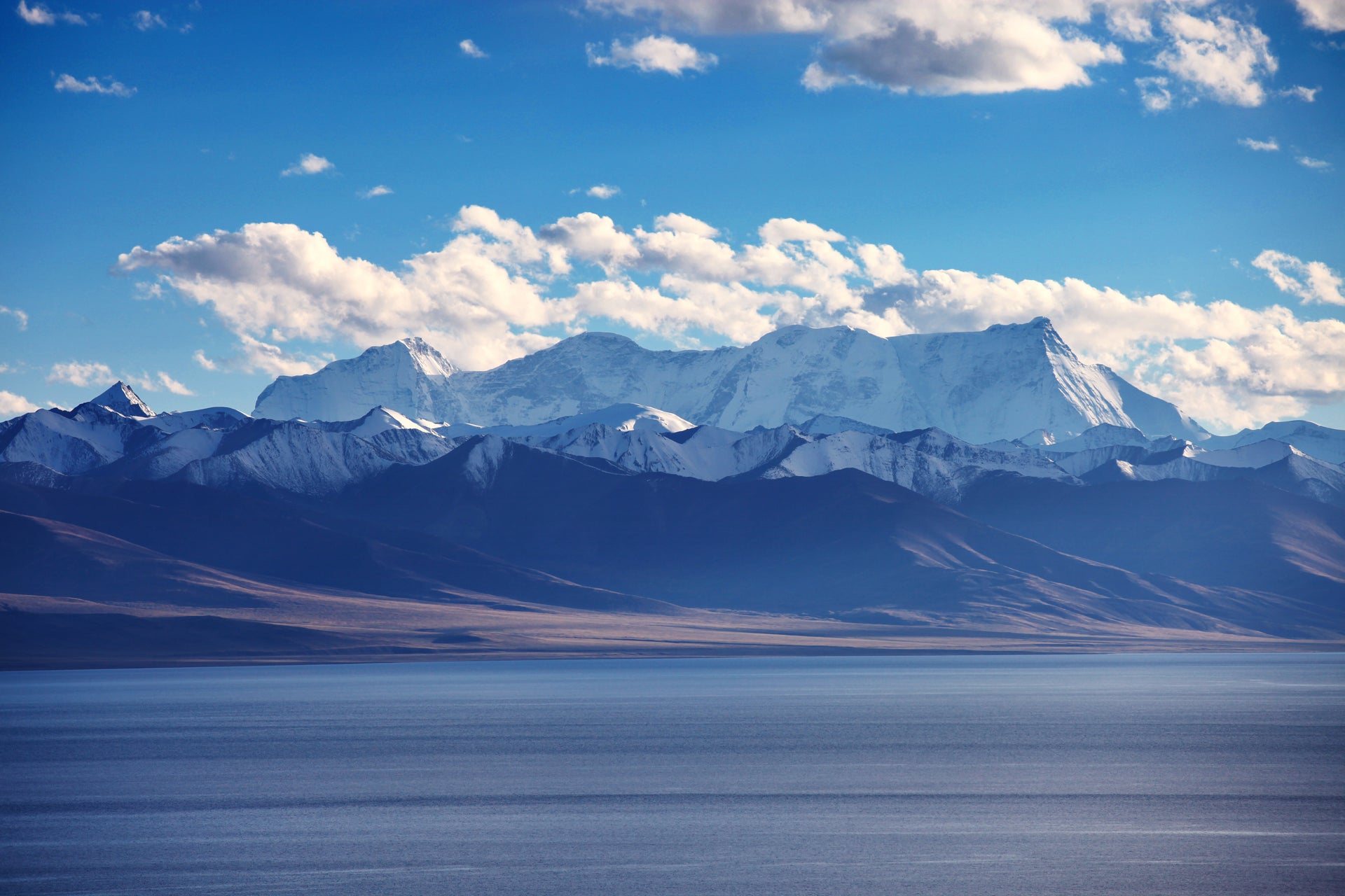 Panoramic Tibetan Plateau with snow-capped Himalayas above a tranquil alpine lake