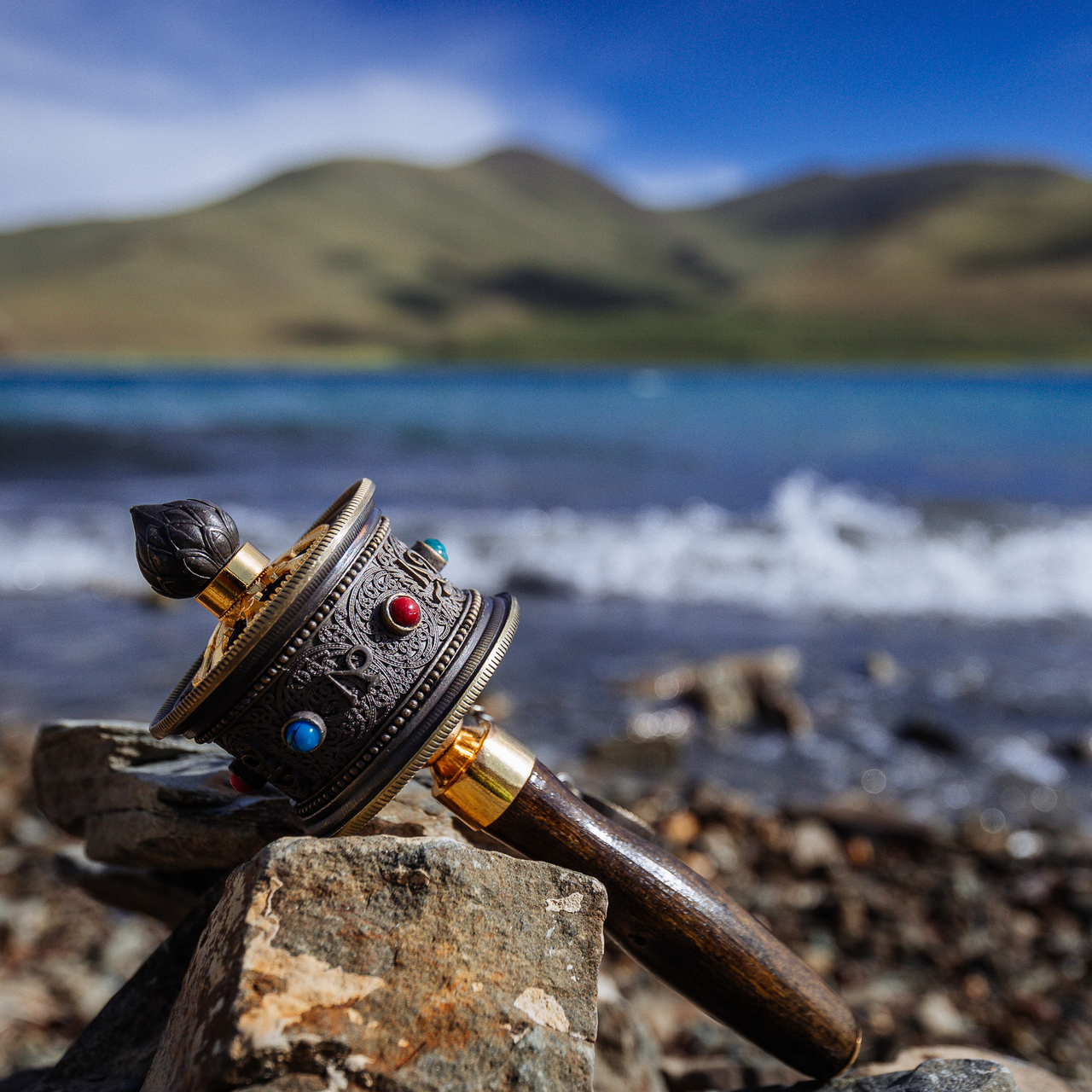 Prayer wheel by a lakeshore during a journey across the Tibetan Plateau