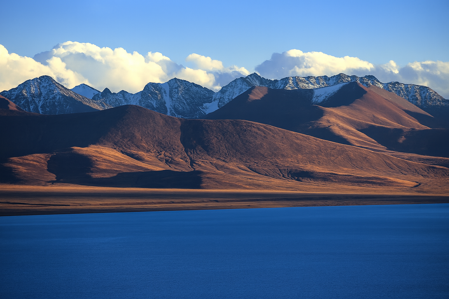 Shoreline of Namtso Lake beneath wide Tibetan sky