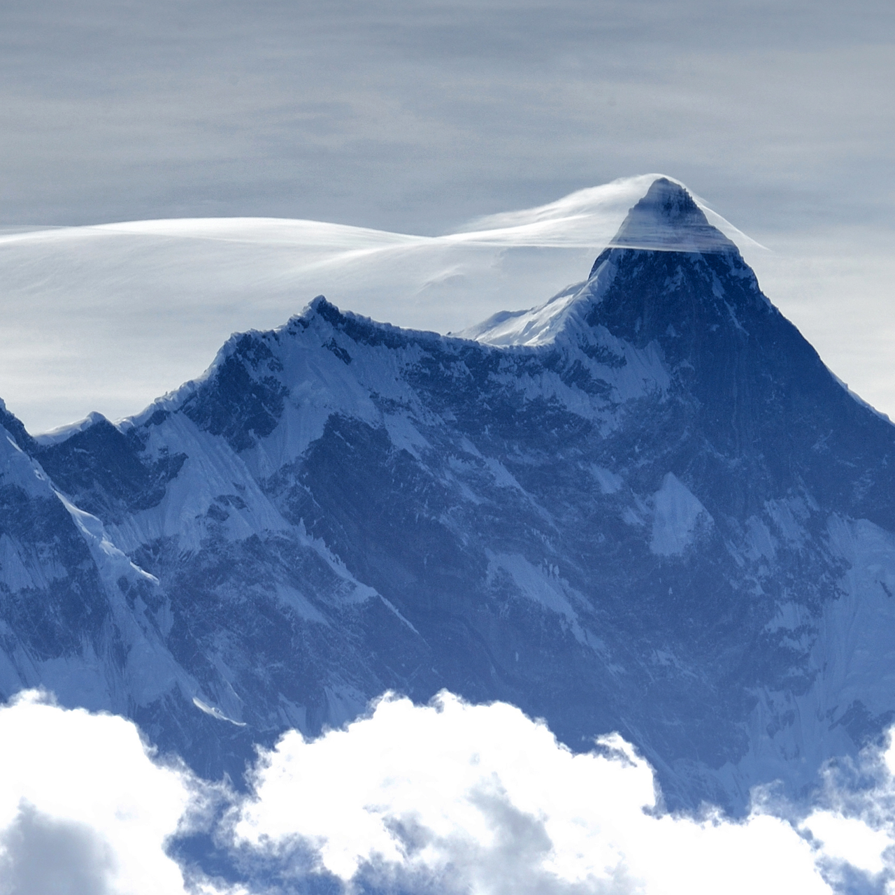 Snow-capped mountain peak with clouds in the foreground