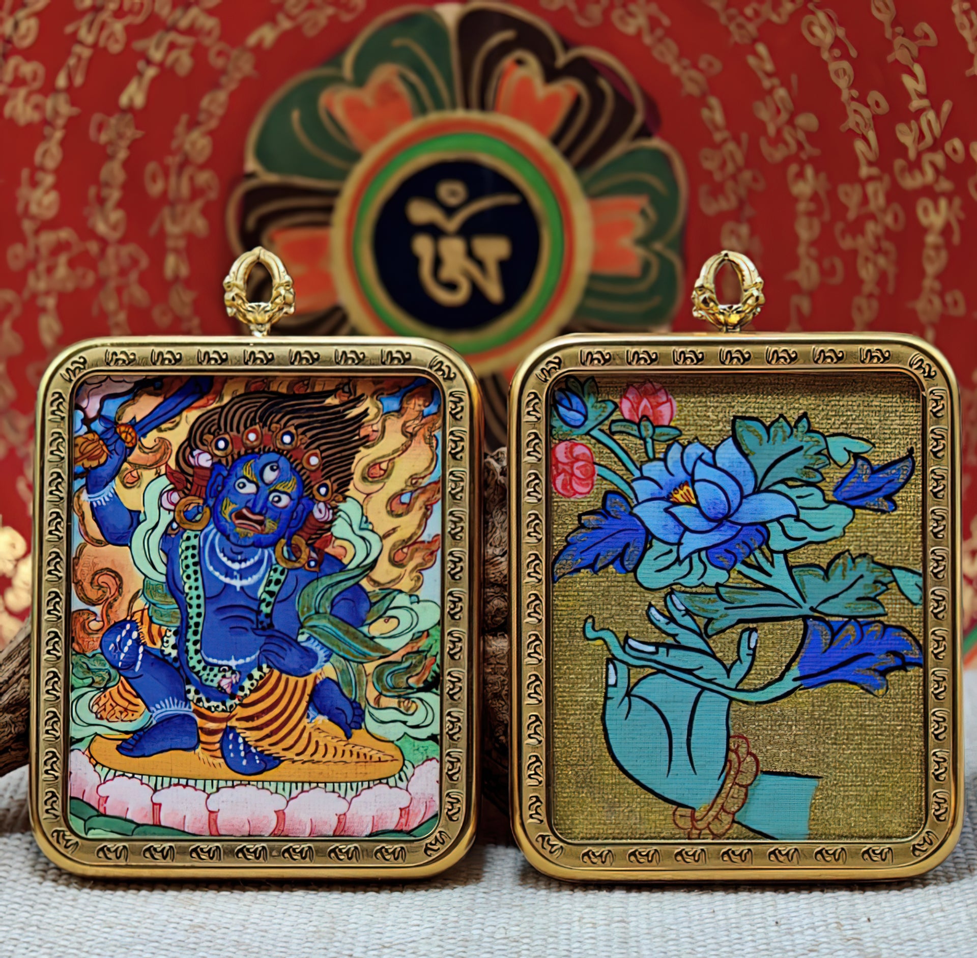 Two framed Tibetan thangka paintings featuring a blue wrathful deity and a lotus design