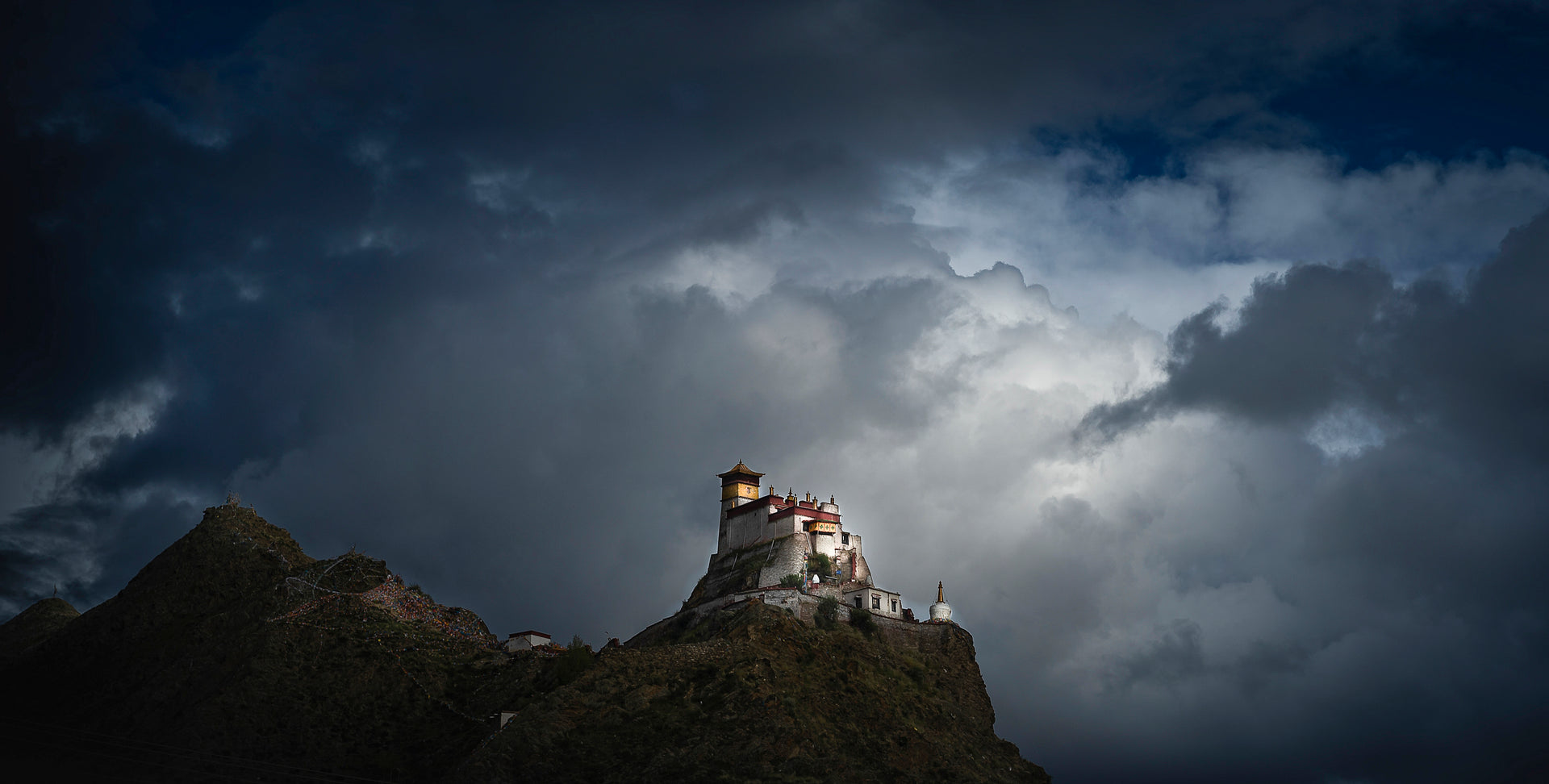 Yumbu Lhakhang palace on a ridge in Tibet under dramatic storm clouds
